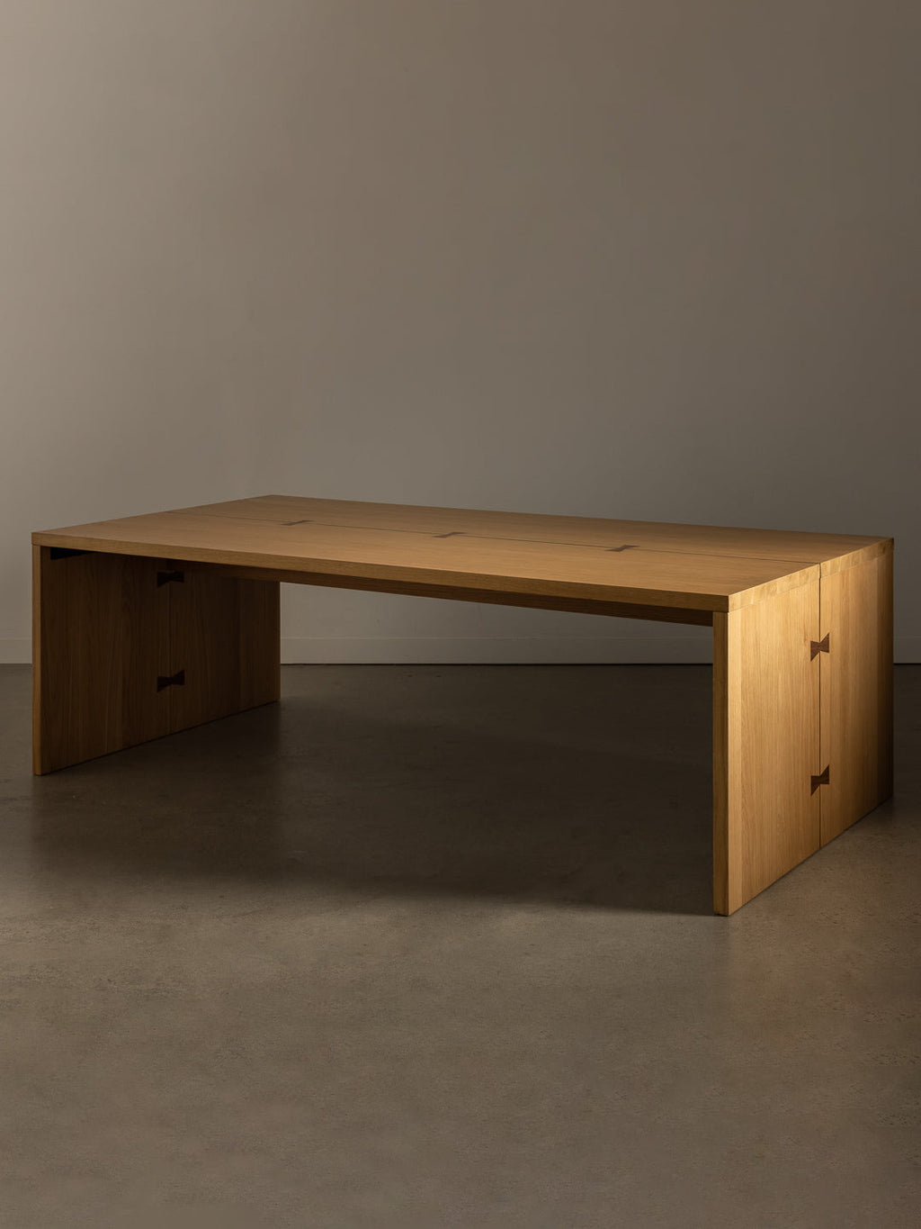 Bowtie dining table against stone toned studio background