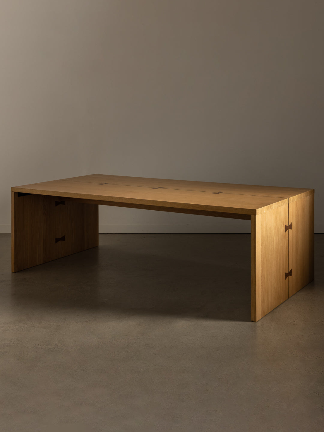 Bowtie dining table against stone toned studio background