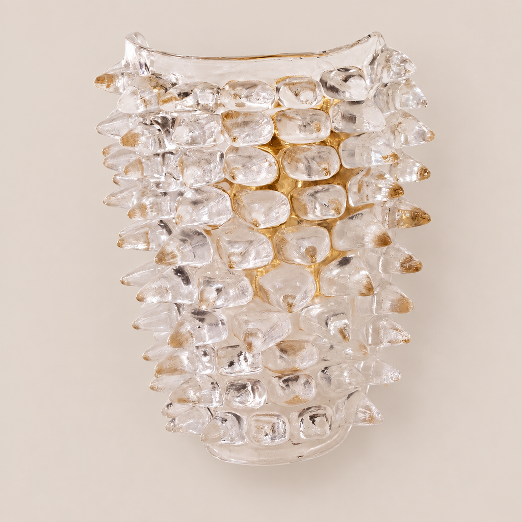 Clear sculptural Murano glass wall sconce on stone background