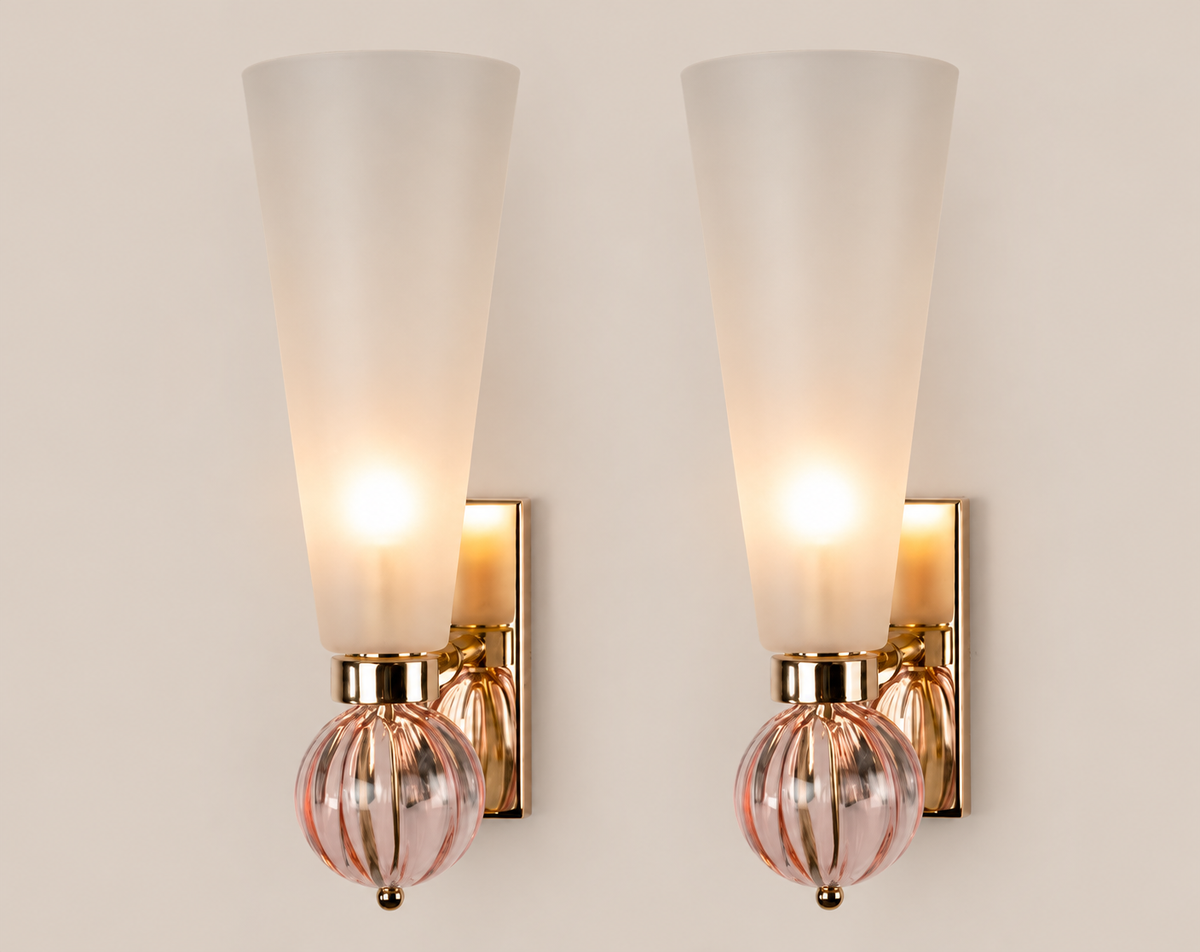 Pair of pink orb Murano glass sconces on warm stone