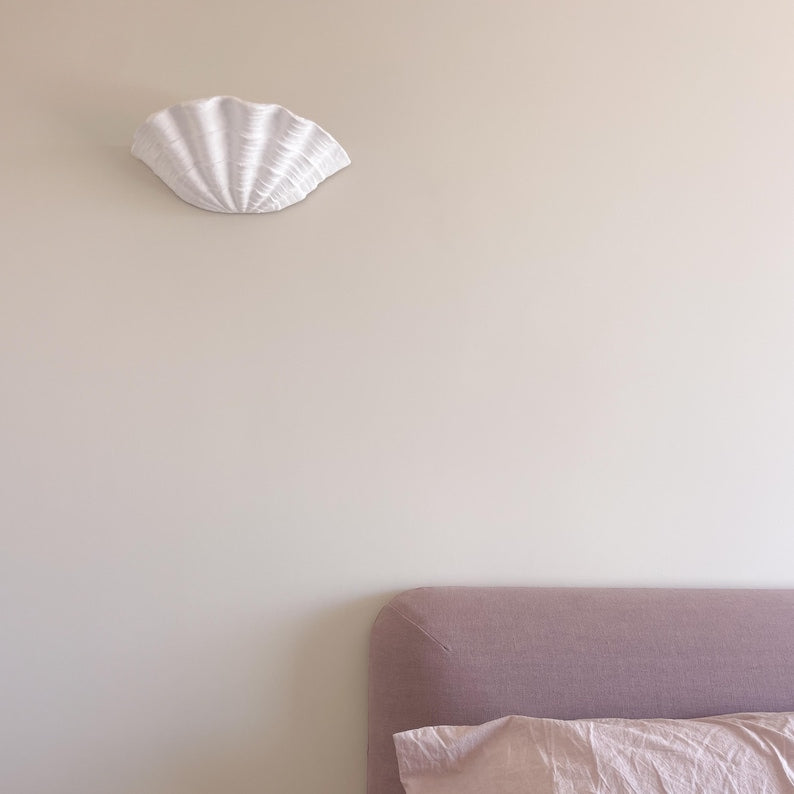 Coquillage plaster sconce installed above bed